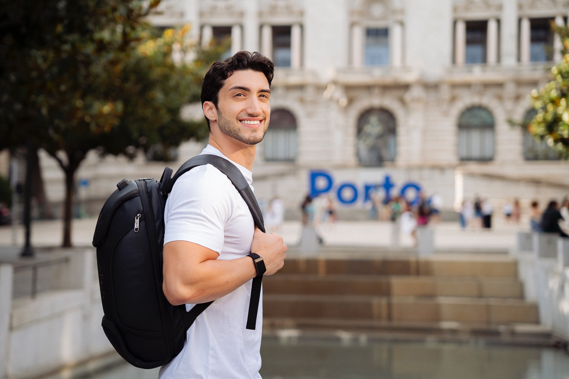 Enzo em Portugal, com a mochila em frente ao letreiro de Porto